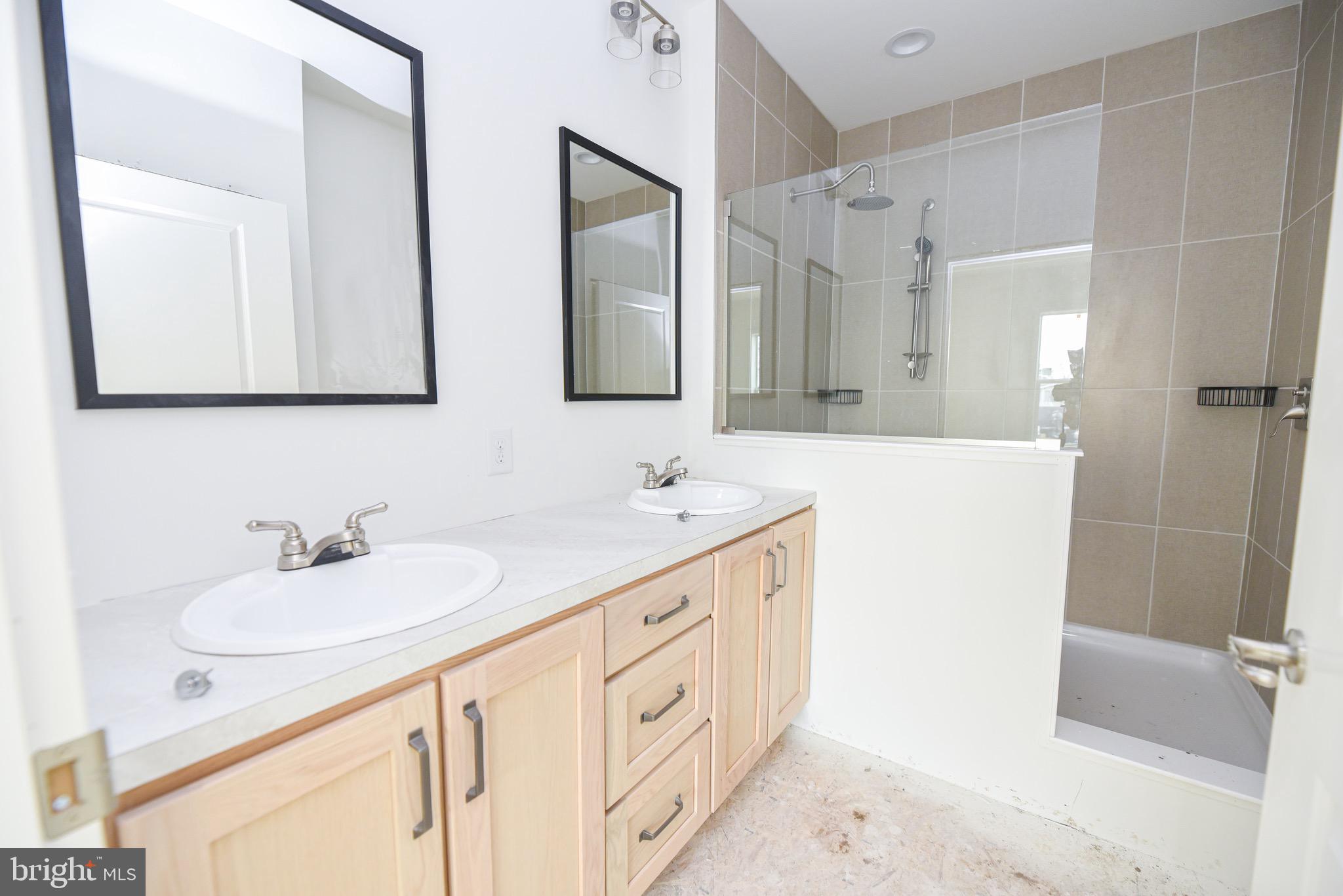 34340 River Road, Unit 129 Long Neck, DE 19966 - Photo 12 of 16 a bathroom with double vanity sink and a mirror