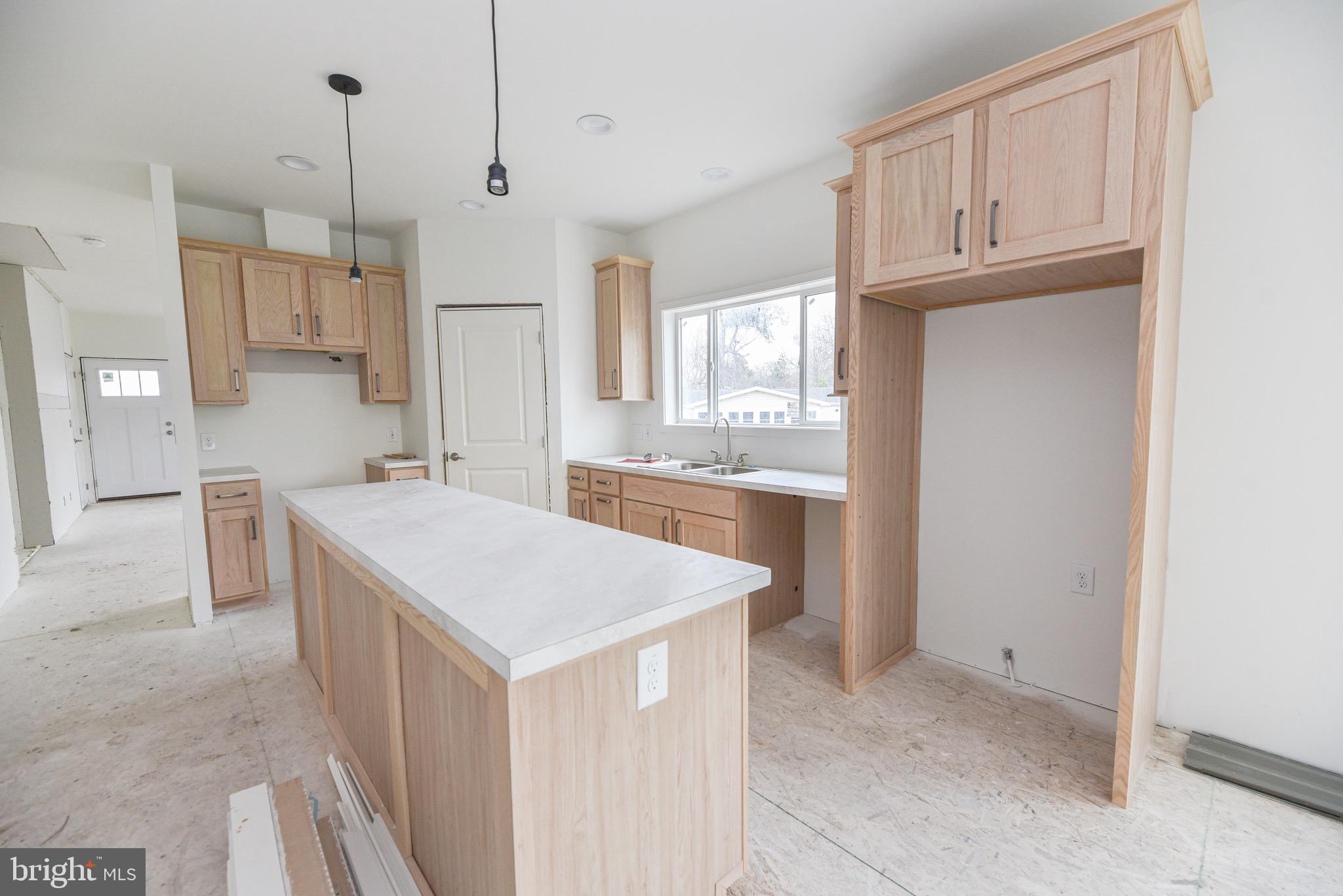 34340 River Road, Unit 129 Long Neck, DE 19966 - Photo 6 of 16 a kitchen with kitchen island cabinets and refrigerator