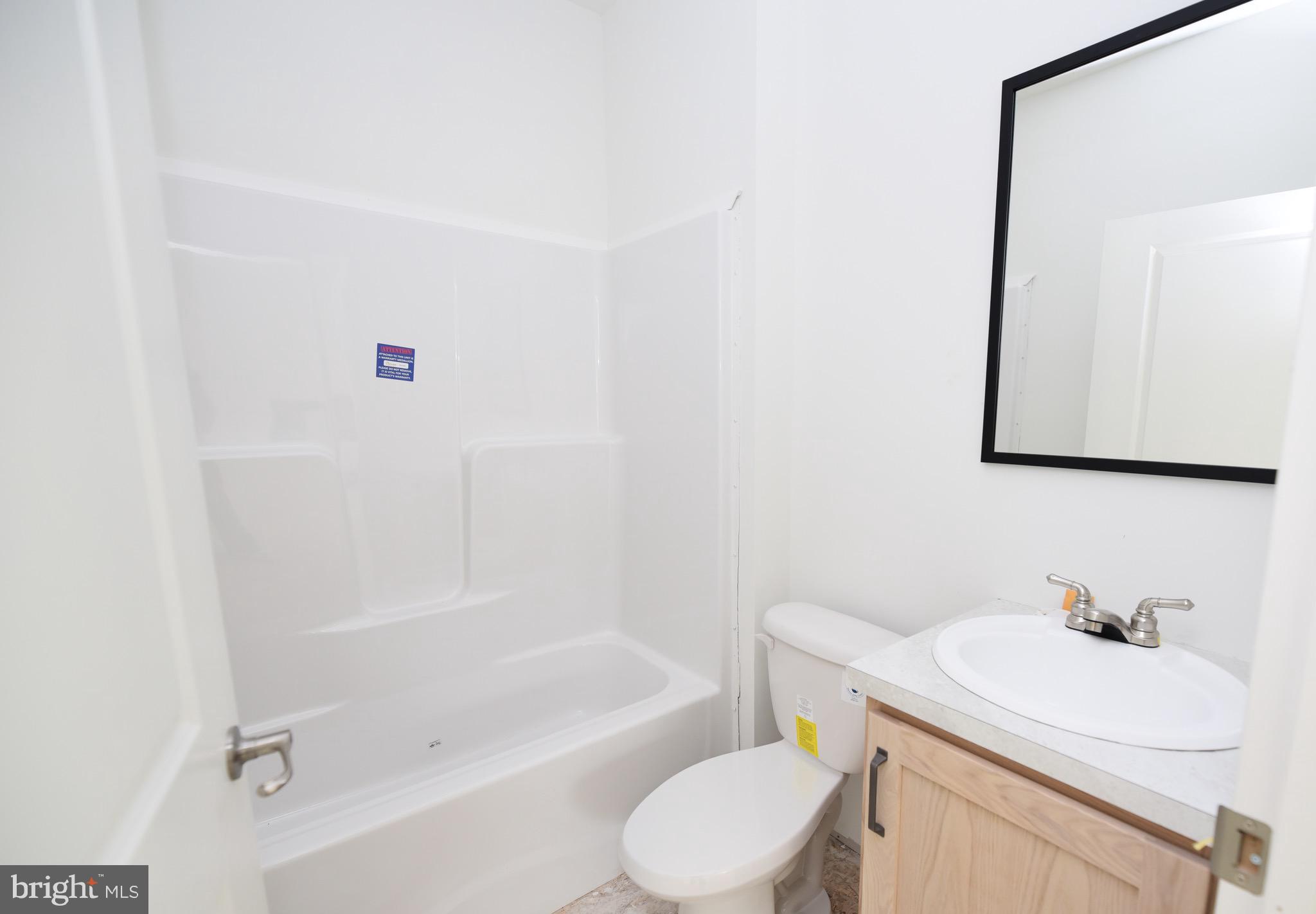 34340 River Road, Unit 129 Long Neck, DE 19966 - Photo 10 of 16 a bathroom with a sink a toilet and a bathtub