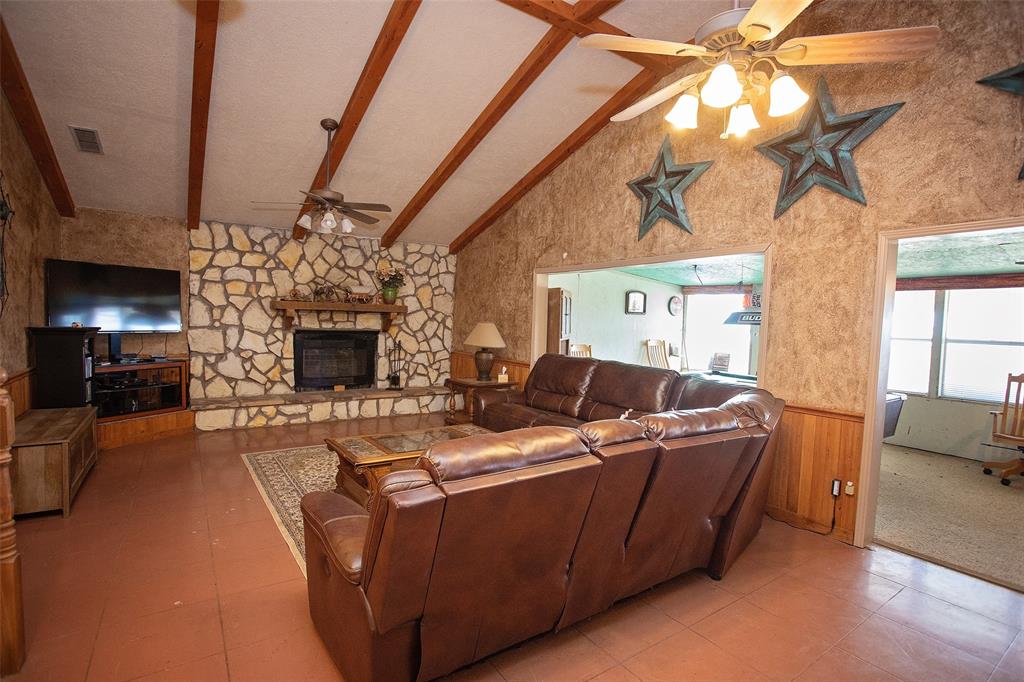 1193 Eastside Lake Road Graham, TX 76450 - Photo 19 of 38 a living room with furniture a fireplace and a flat screen tv