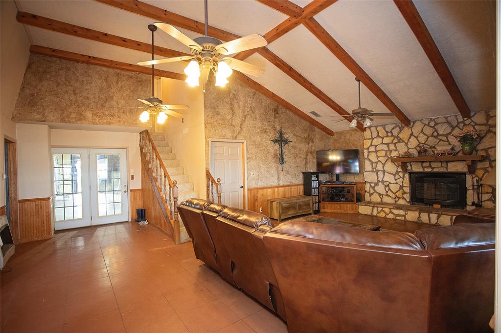 1193 Eastside Lake Road Graham, TX 76450 - Photo 20 of 38 a living room with couches a fireplace with wooden floor