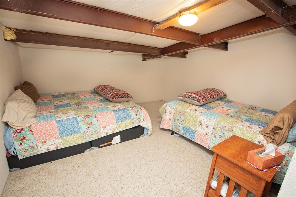 1193 Eastside Lake Road Graham, TX 76450 - Photo 28 of 38 a bedroom with two bed and a white comforter