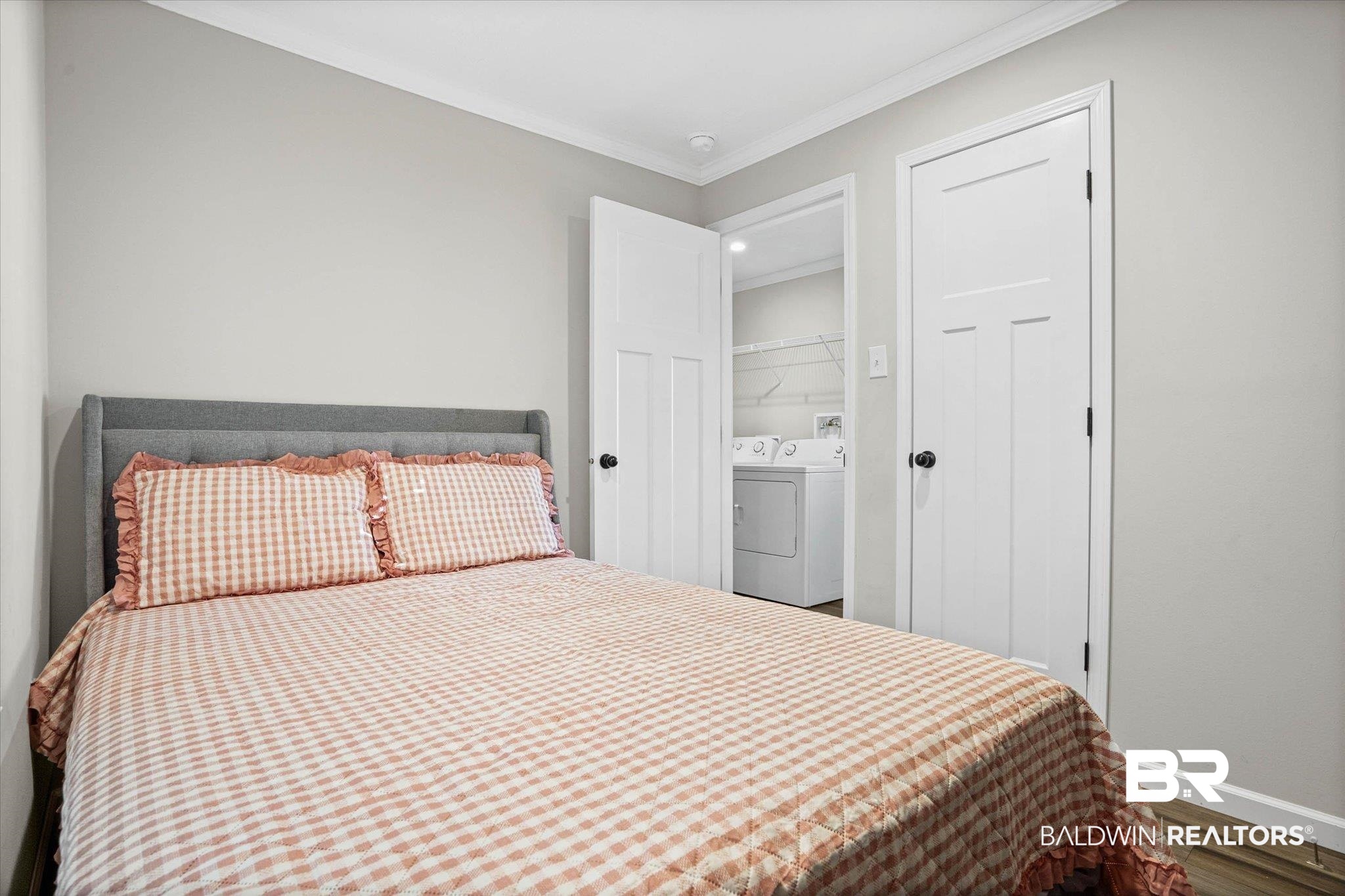 1325 Ridgewood Drive Lillian, AL 36549 - Photo 11 of 32 Bedroom featuring crown molding, washing machine and clothes dryer, and wood finished floors