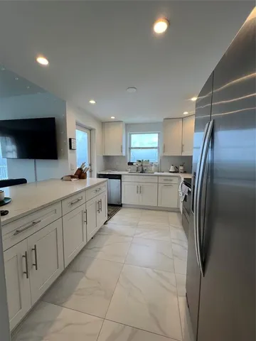 a large kitchen with cabinets and stainless steel appliances