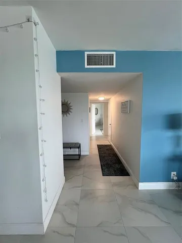 a view of a hallway to rooms and stairs