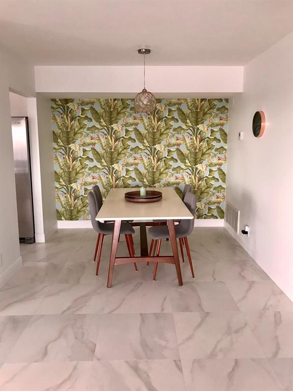 1200 Hibiscus Avenue, Unit 1501 Pompano Beach, FL 33062 - Photo 32 of 40 a dining room with furniture and window