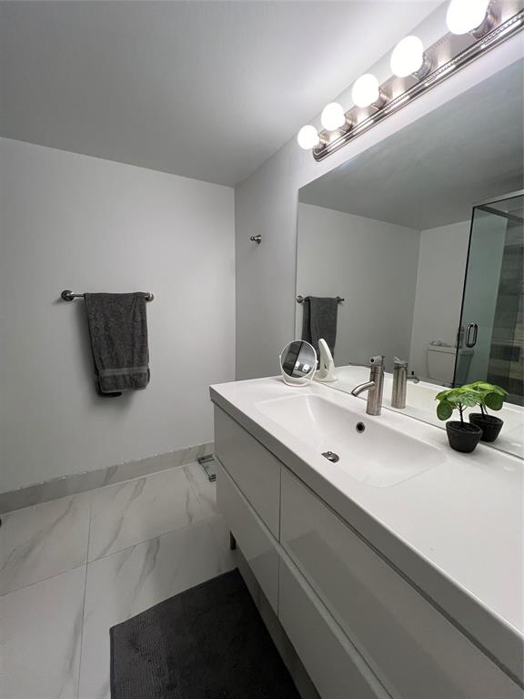 1200 Hibiscus Avenue, Unit 1501 Pompano Beach, FL 33062 - Photo 6 of 40 a bathroom with a double vanity sink and a mirror
