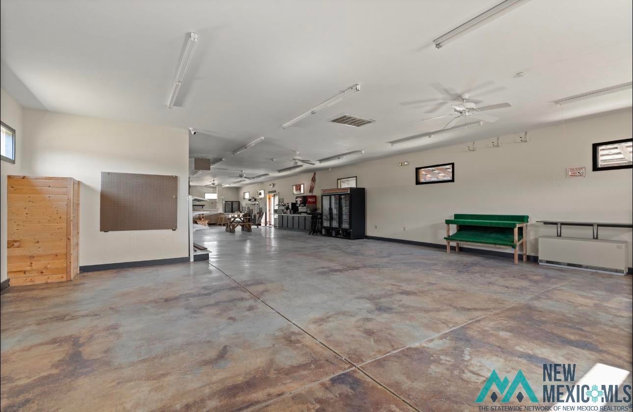 371 Candy Kitchen Road Candy Kitchen, NM 87357 - Photo 36 of 49 Expansive open-concept space featuring durable concrete flooring, multiple ceiling fans, and abundant fluorescent lighting