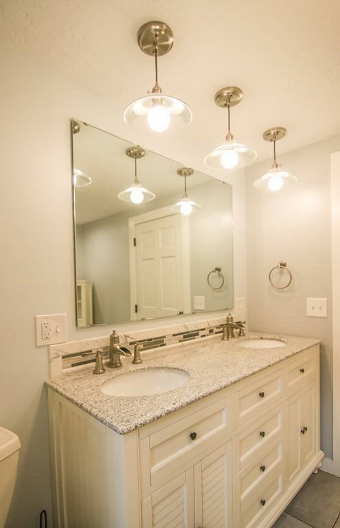 69 John Gilbert Road West Brookfield, MA 01585 - Photo 38 of 41 a bathroom with a granite countertop sink a large mirror and vanity