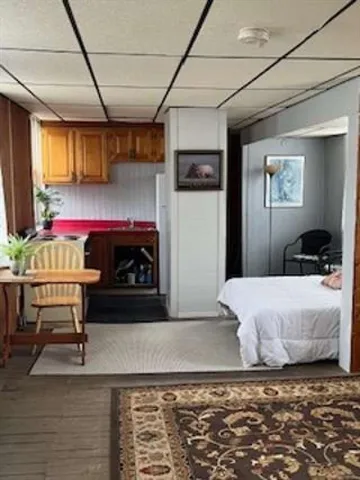 a bedroom with a bed and a view of kitchen