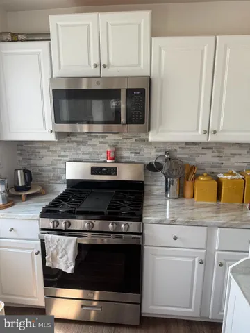 a kitchen with granite countertop a stove and a sink