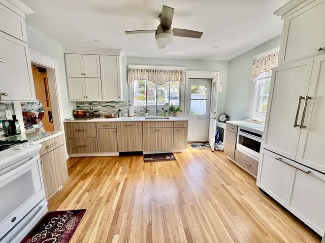 a kitchen with granite countertop wooden floors a stove and white stainless steel appliances