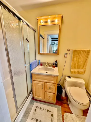 a bathroom with a granite countertop sink toilet and shower