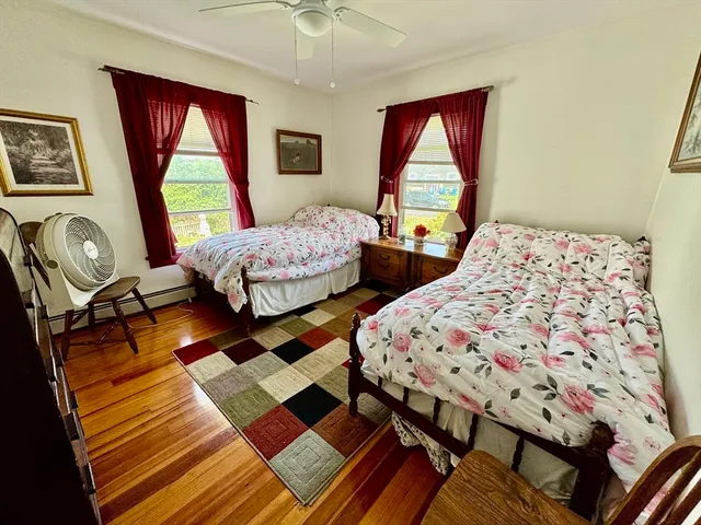 a bedroom with two beds window and a flat screen tv