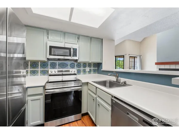 a kitchen with stainless steel appliances a stove sink and microwave