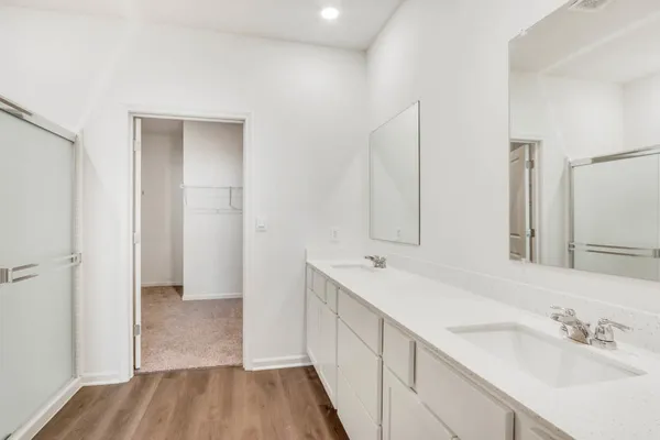 a bathroom with a double vanity sink a mirror and a shower