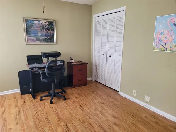 a view of a workspace with furniture and a window