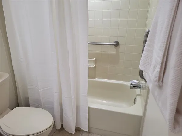 a white toilet sitting next to a bath tub