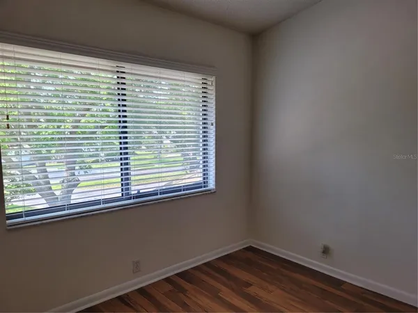 a view of a room with wooden floor and a window