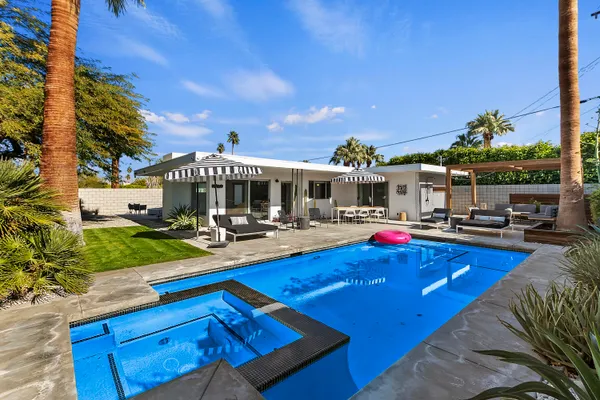 a view of a house with swimming pool and sitting area