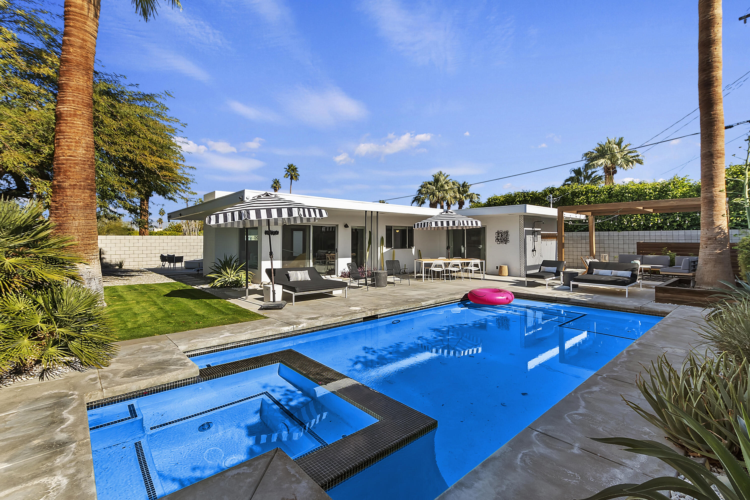 a view of a house with swimming pool and sitting area
