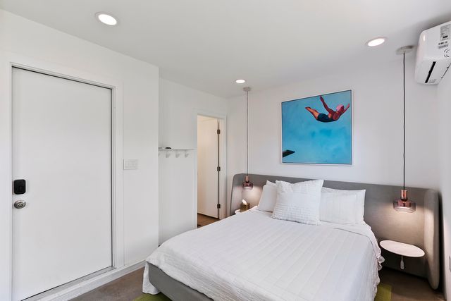 a bedroom with a bed and a painting on the wall