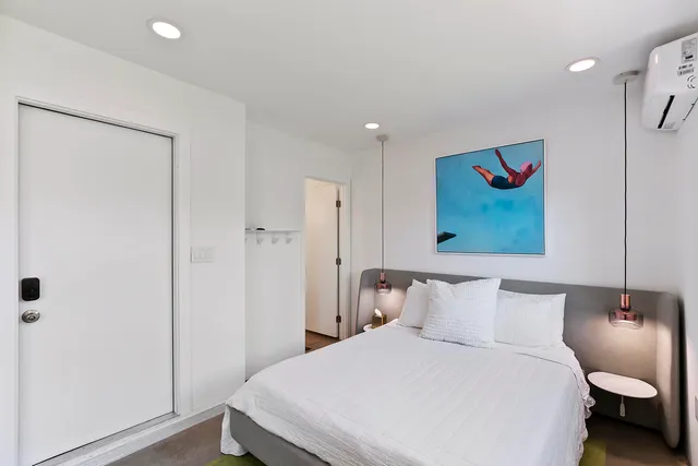 a bedroom with a bed and a painting on the wall