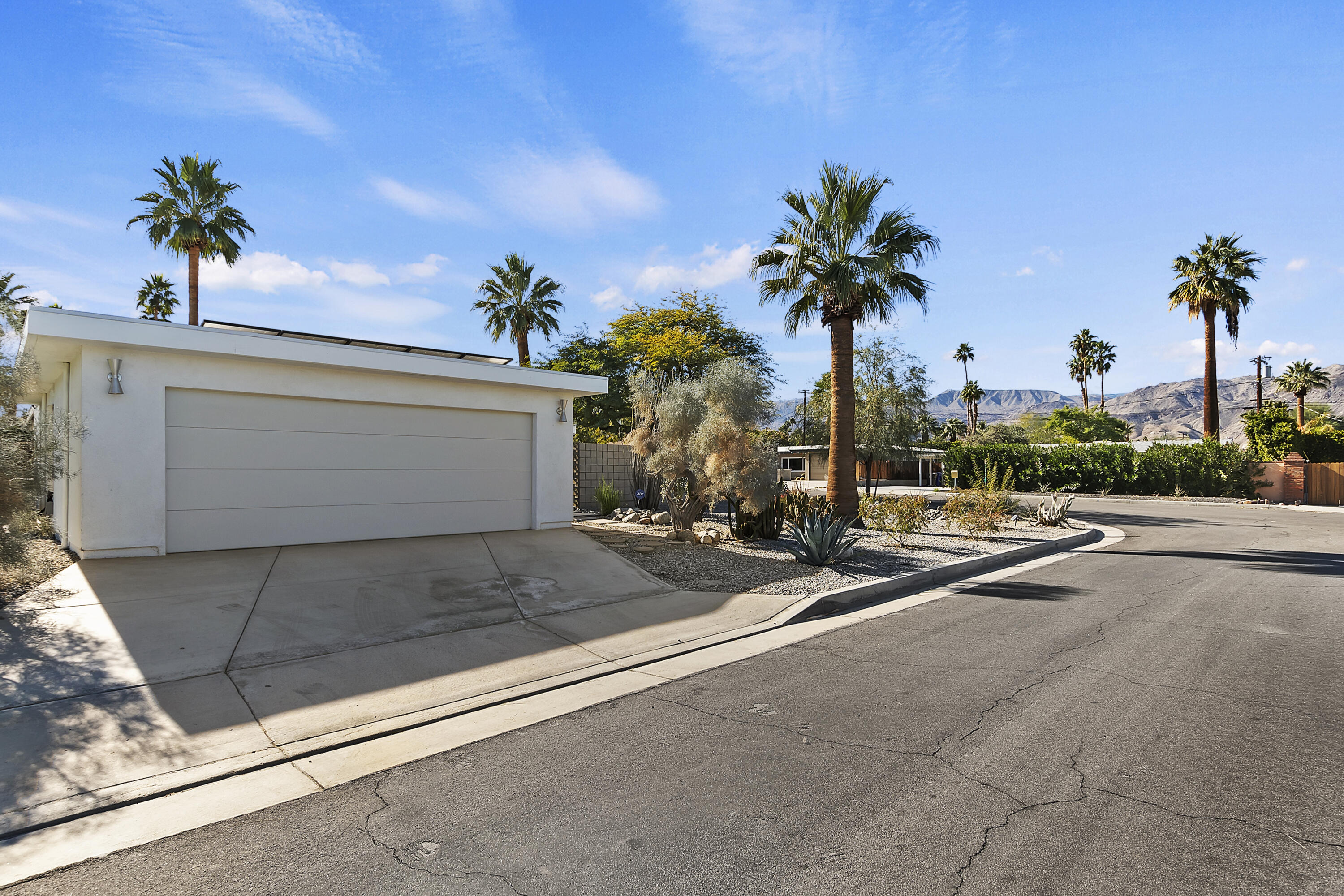 45876 Abronia Trail Palm Desert, CA 92260 - Photo 3 of 26 a view of a street with a cars parked