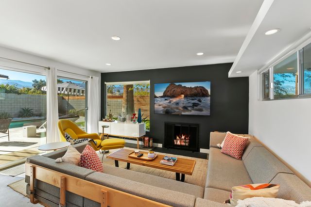 a living room with furniture a fireplace and a flat screen tv