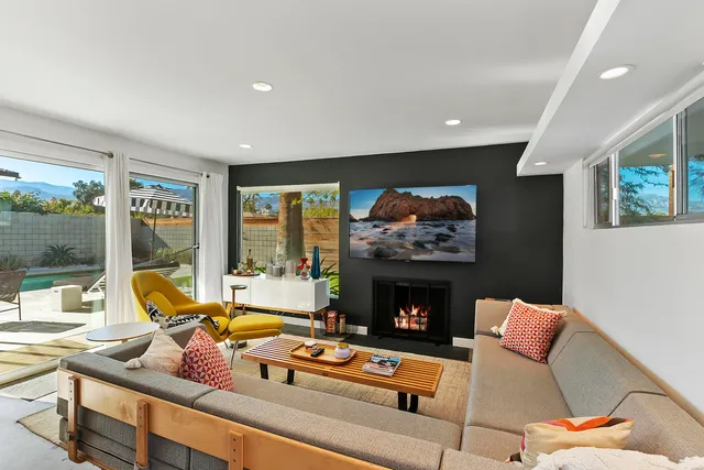 a living room with furniture a fireplace and a flat screen tv