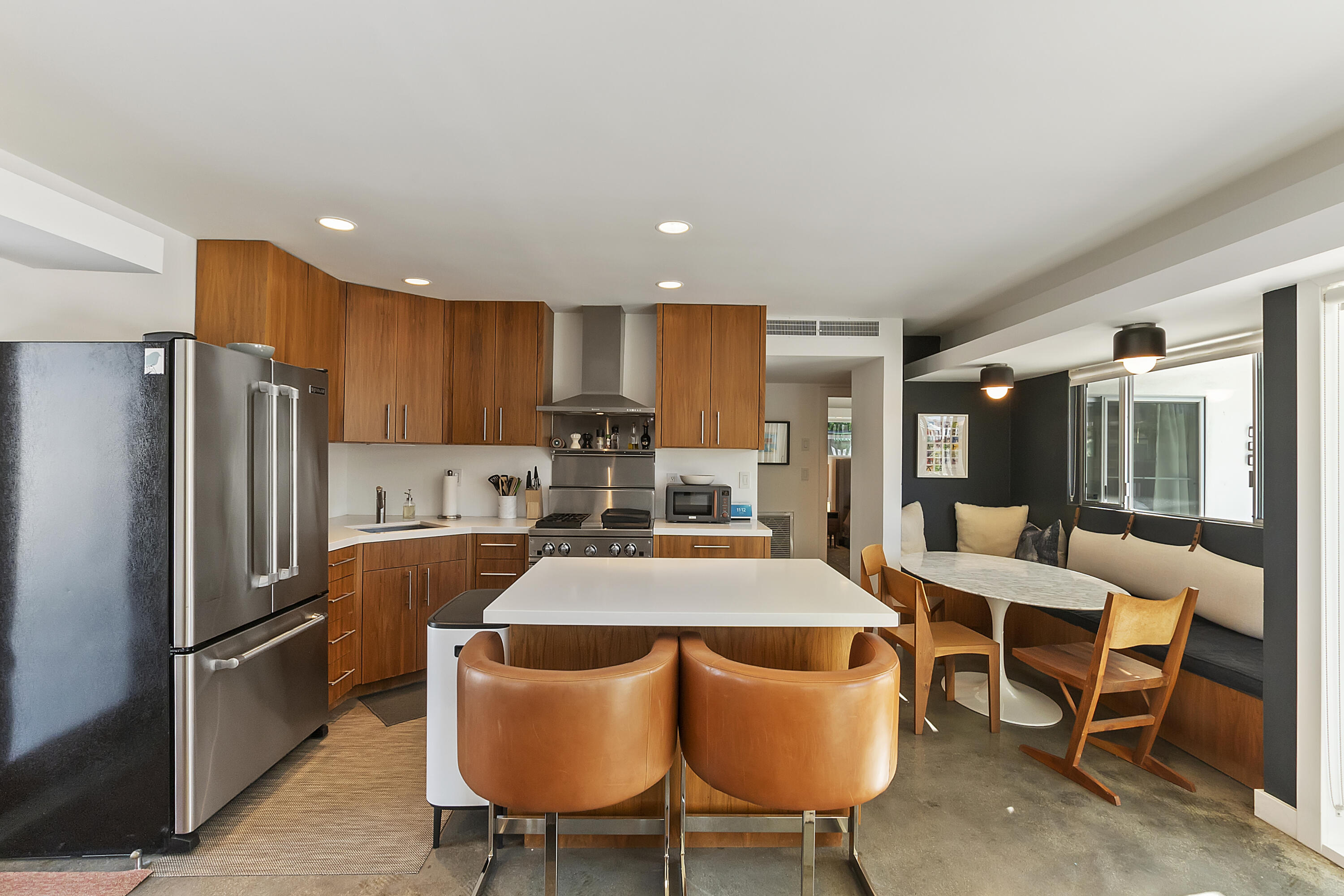45876 Abronia Trail Palm Desert, CA 92260 - Photo 9 of 26 a kitchen with stainless steel appliances granite countertop a dining table chairs refrigerator and microwave