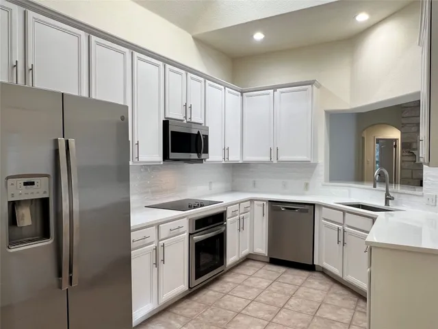 a kitchen with a sink appliances and cabinets