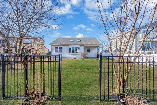 a view of a brick house with a big yard and plants