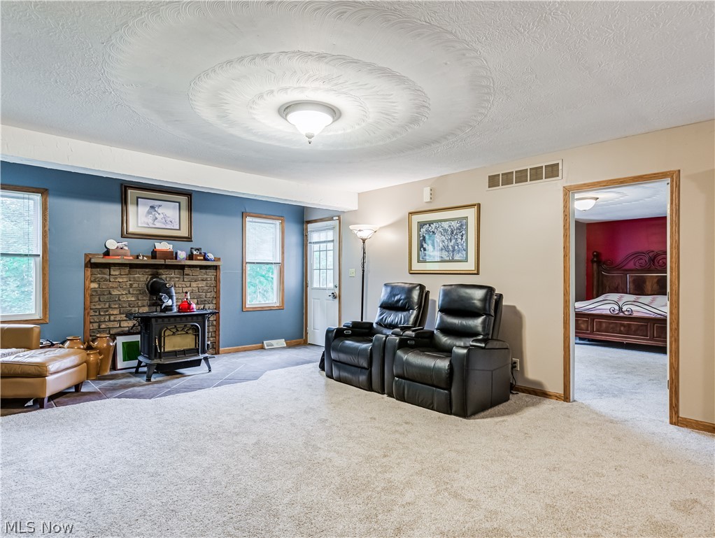 2700 Old Forge Road Kent, OH 44240 - Photo 5 of 34 Carpeted living room with a wood stove and a textured ceiling