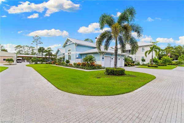 a view of a white house with a swimming pool and a yard