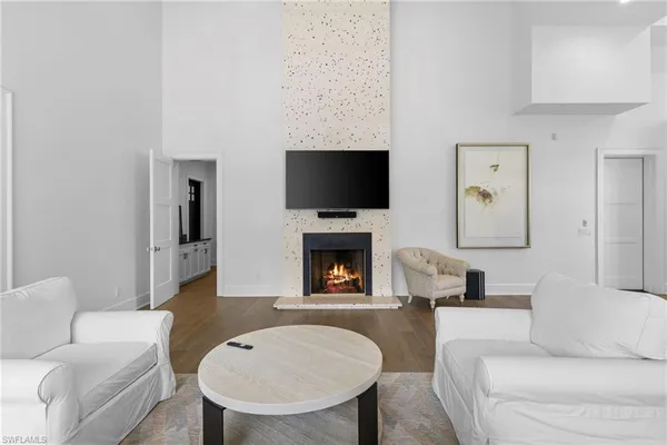 a living room with furniture a fireplace and a flat screen tv