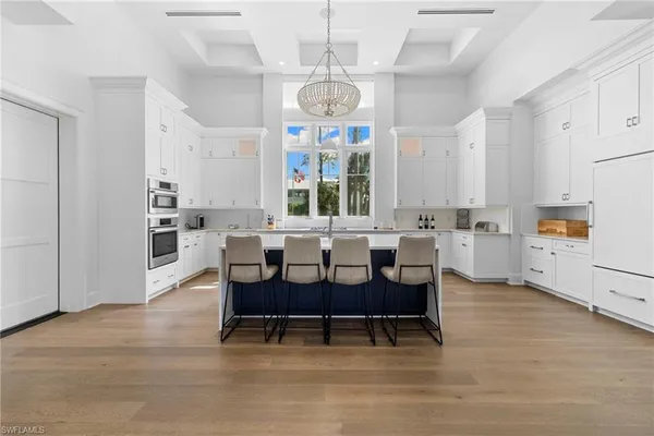a large white kitchen with a large window and white cabinets