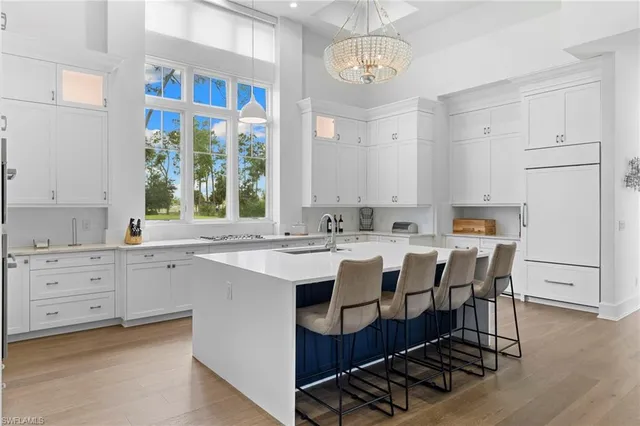 a large kitchen with stainless steel appliances a stove a sink dishwasher and cabinets with wooden floor