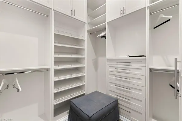 a view of walk in closet with empty racks