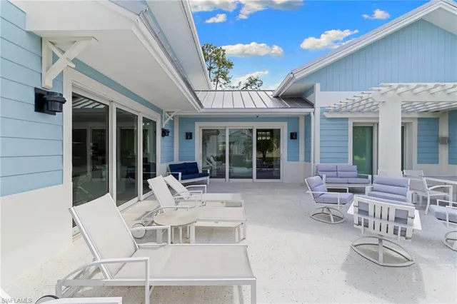 a view of a patio with couches table and chairs and potted plants