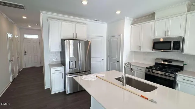 a kitchen with stainless steel appliances granite countertop a refrigerator and a stove top oven