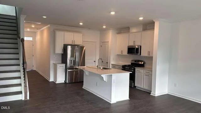 a kitchen with stainless steel appliances kitchen island granite countertop a refrigerator and a stove top oven