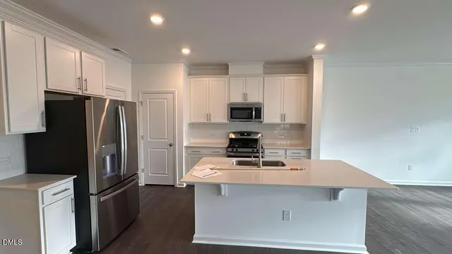 a kitchen with stainless steel appliances a refrigerator stove microwave and sink