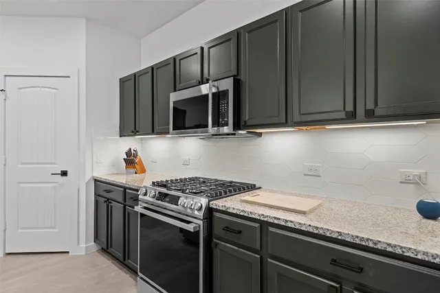a kitchen with granite countertop cabinets stainless steel appliances and sink