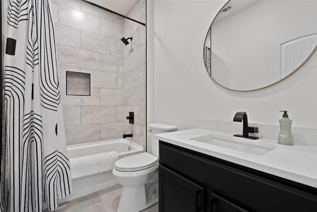 a bathroom with a sink a toilet a mirror and shower