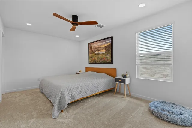 a bedroom with a large bed and a painting on the wall