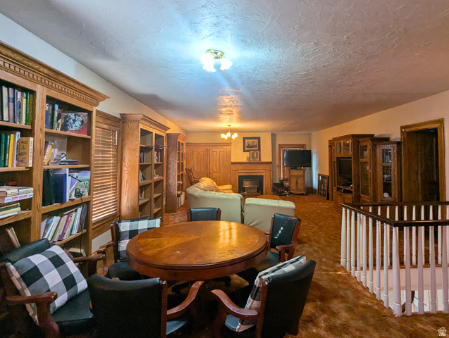 190 North 200 E Street Beaver, UT 84713 - Photo 31 of 40 Spacious room featuring extensive built-in wood bookshelves, a central fireplace with wood mantel, and wood-finish flooring