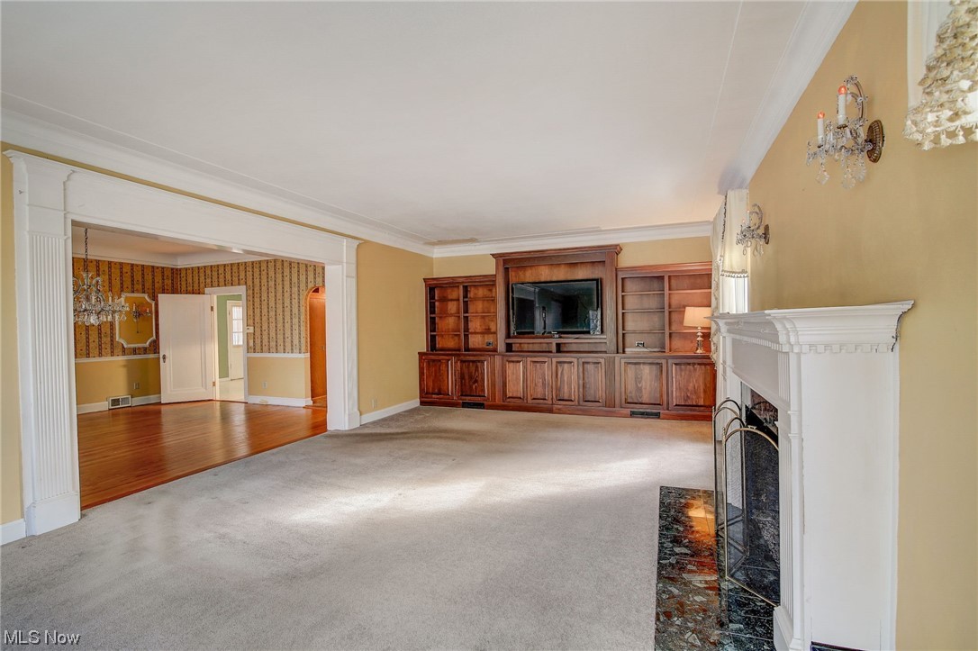 45555 North Ridge Road Amherst, OH 44001 - Photo 10 of 36 Unfurnished living room featuring crown molding and built-in bookshelves