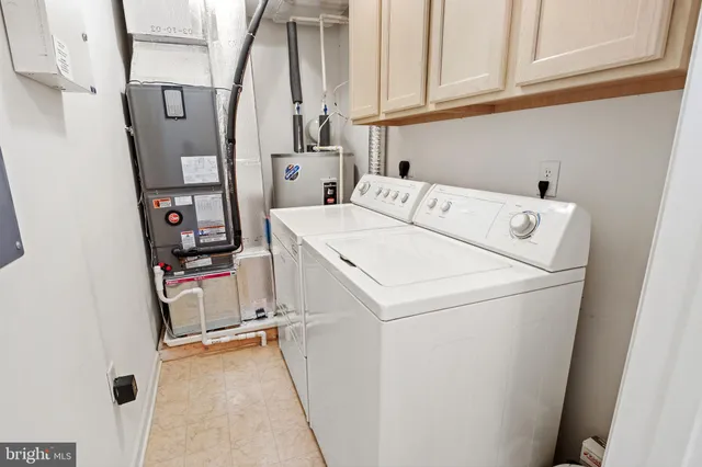 an empty room with chandelier fan and windows