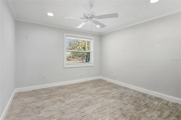 an empty room with a window and a fan